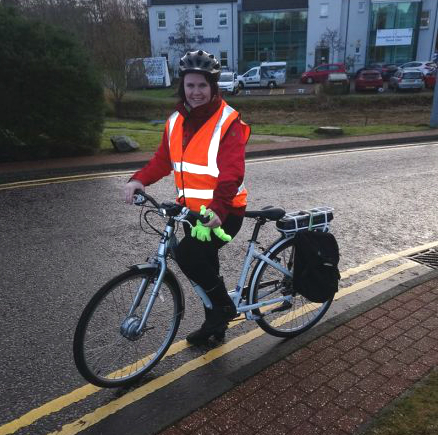A photo of Ailsa on an electric bike just outside of Larch House
